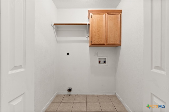 laundry room with light tile patterned floors, hookup for a washing machine, electric dryer hookup, and cabinets