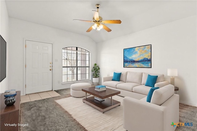 carpeted living area featuring ceiling fan, vaulted ceiling, and tile patterned flooring