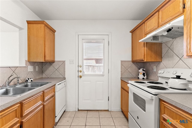 kitchen featuring sink, white appliances, light tile patterned floors, and tasteful backsplash