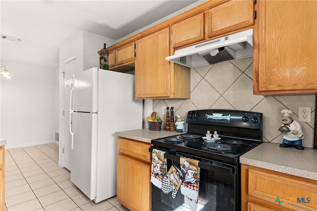 kitchen with decorative backsplash, light tile patterned floors, white refrigerator, and black electric range