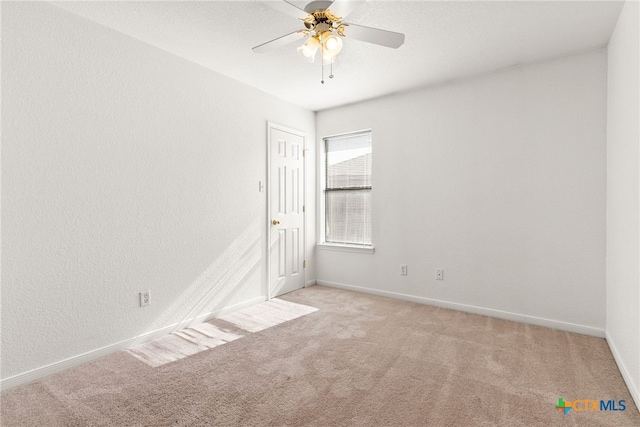 spare room with ceiling fan and light colored carpet