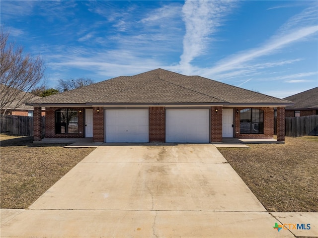 single story home featuring a garage, driveway, a shingled roof, fence, and brick siding