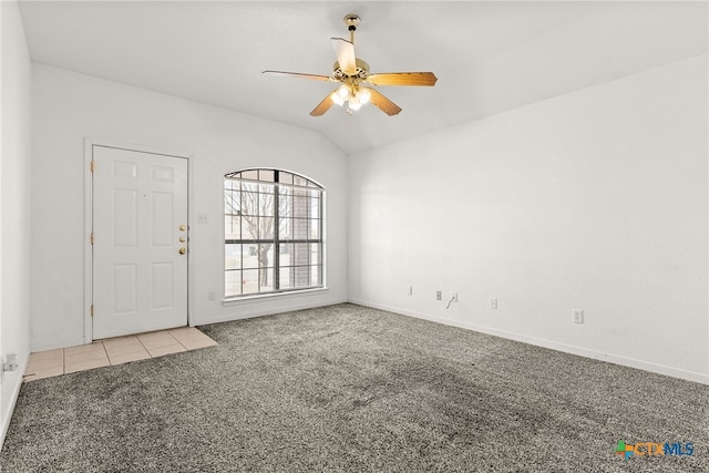 carpeted spare room featuring ceiling fan and vaulted ceiling