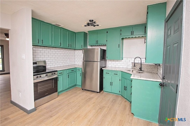 kitchen with decorative backsplash, ceiling fan, sink, and stainless steel appliances