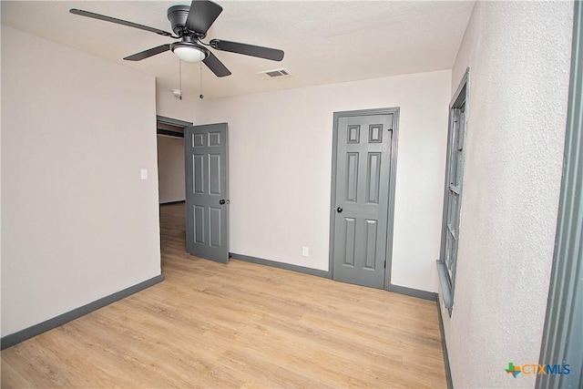 unfurnished bedroom with ceiling fan and light hardwood / wood-style flooring