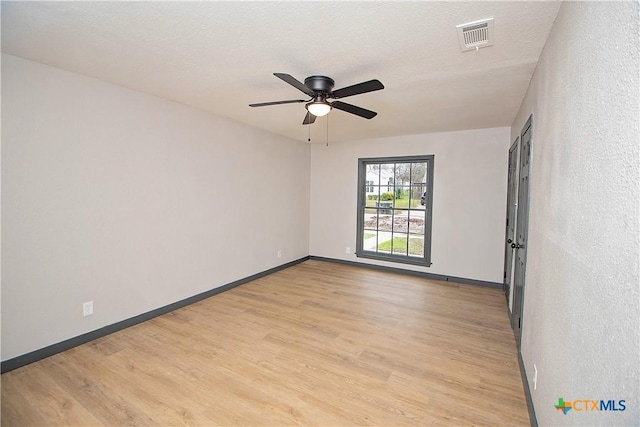 spare room featuring a textured ceiling, light wood-type flooring, and ceiling fan