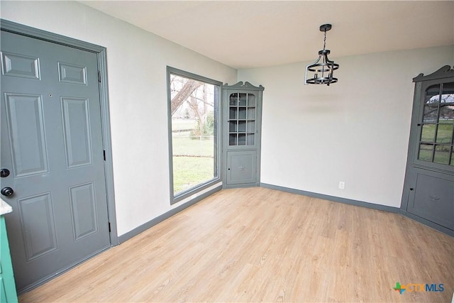 unfurnished dining area with light hardwood / wood-style floors and a healthy amount of sunlight