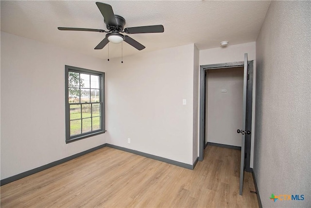 spare room with ceiling fan, a textured ceiling, and light hardwood / wood-style flooring