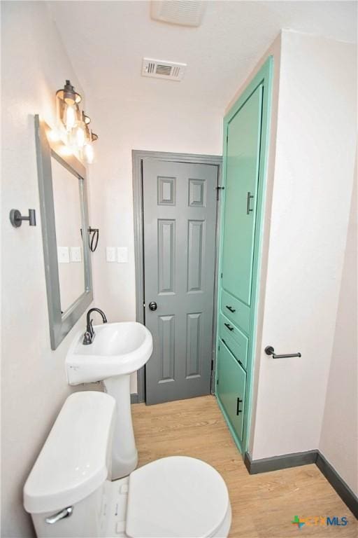 bathroom with wood-type flooring and toilet