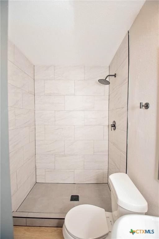 bathroom featuring toilet and tiled shower