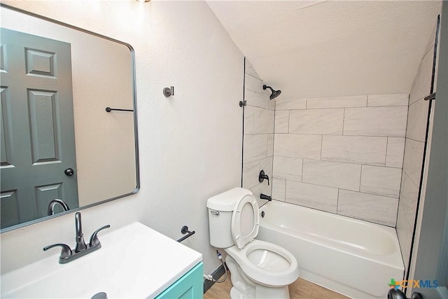 full bathroom featuring vanity, a textured ceiling, toilet, and tiled shower / bath