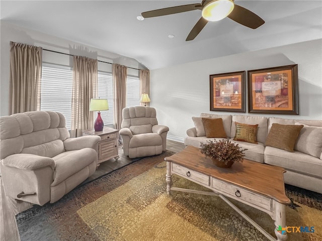 living area with ceiling fan, baseboards, vaulted ceiling, and dark wood-style flooring