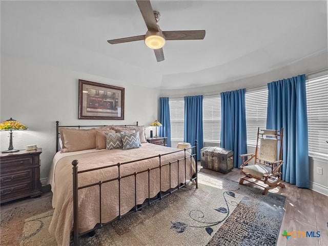 bedroom featuring a ceiling fan, baseboards, and wood finished floors