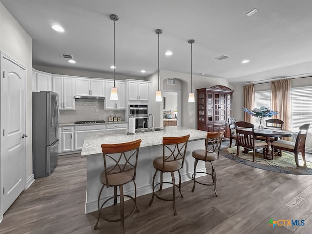 kitchen featuring white cabinetry, appliances with stainless steel finishes, and decorative light fixtures