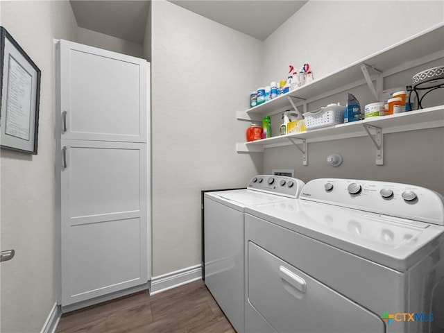 laundry area with cabinet space, washing machine and dryer, baseboards, and dark wood-type flooring