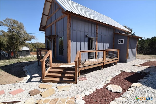 rear view of property with metal roof, board and batten siding, and a deck