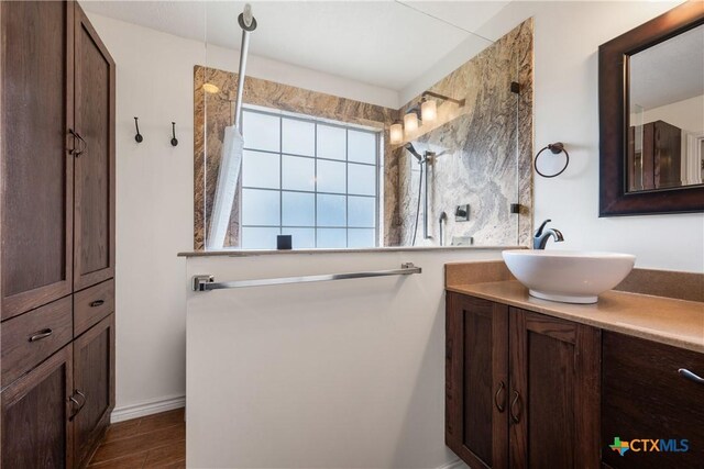 full bathroom featuring a walk in shower, vanity, and wood finished floors