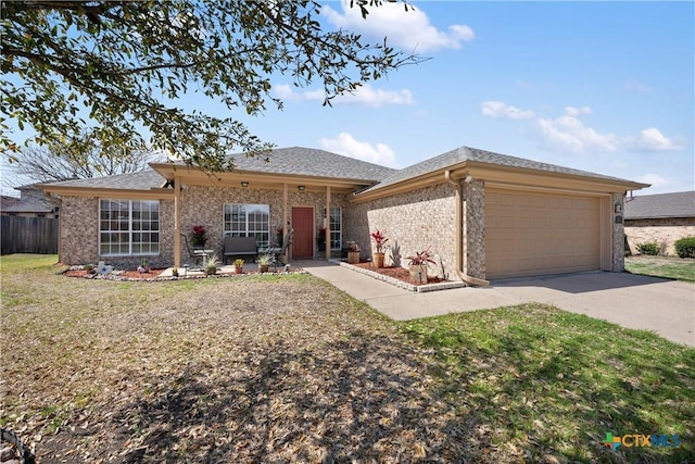 view of front of home featuring brick siding, a shingled roof, a front yard, a garage, and driveway