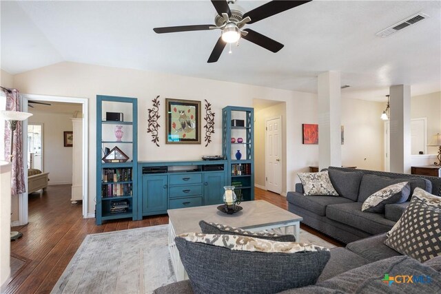 living area featuring visible vents, baseboards, ceiling fan, vaulted ceiling, and dark wood-style flooring