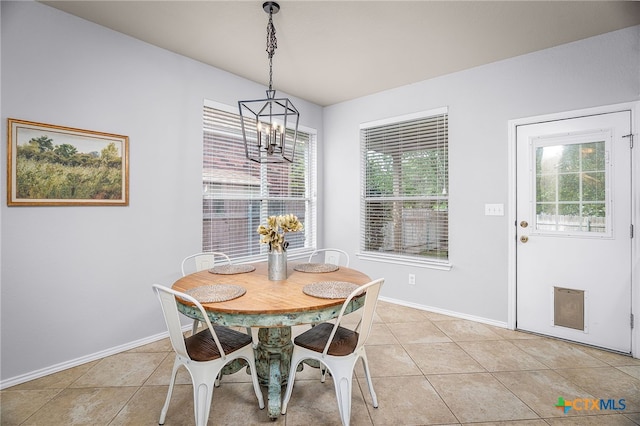 dining room featuring light tile patterned floors, baseboards, and a notable chandelier