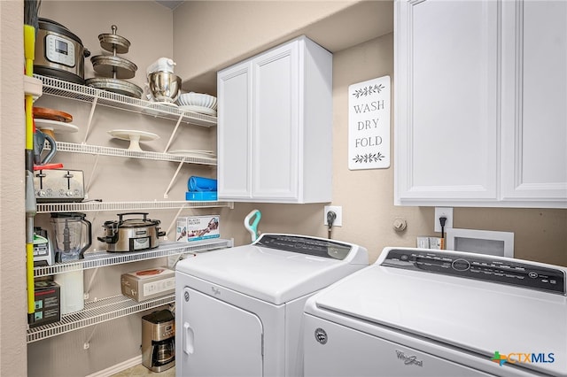 washroom featuring washing machine and clothes dryer and cabinet space