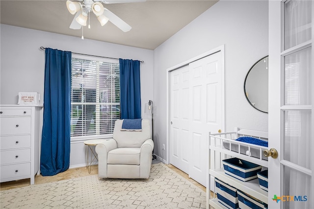 living area with ceiling fan and baseboards