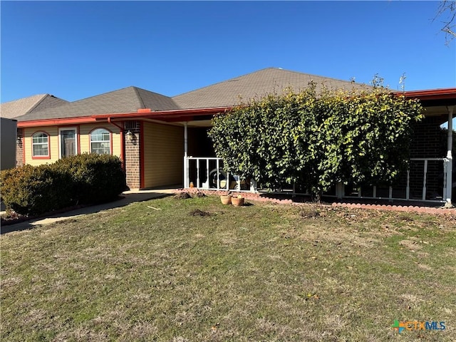 view of front of home featuring a front yard and brick siding