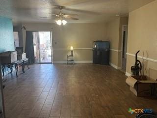 living room featuring wood finished floors, a ceiling fan, and baseboards