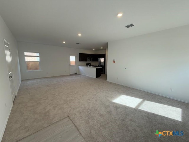 unfurnished living room with light carpet