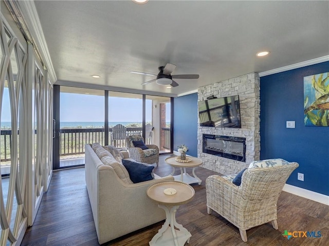 6021 State Highway 361 Unit 109, Port Aransas, TX 78373 - living room featuring ornamental molding, a stone fireplace, a ceiling fan, baseboards, and wood finished floors