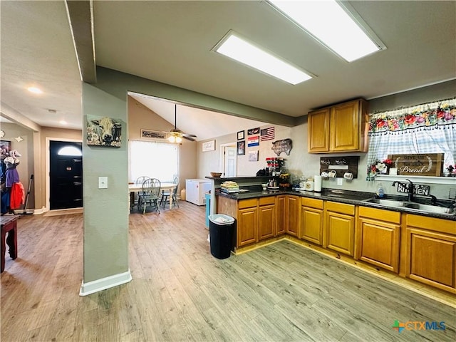 kitchen with lofted ceiling, sink, ceiling fan, light hardwood / wood-style floors, and kitchen peninsula