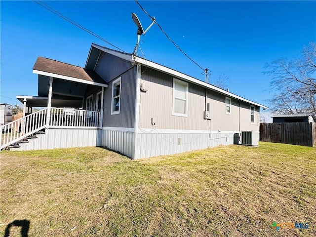 view of side of home with a lawn and central air condition unit