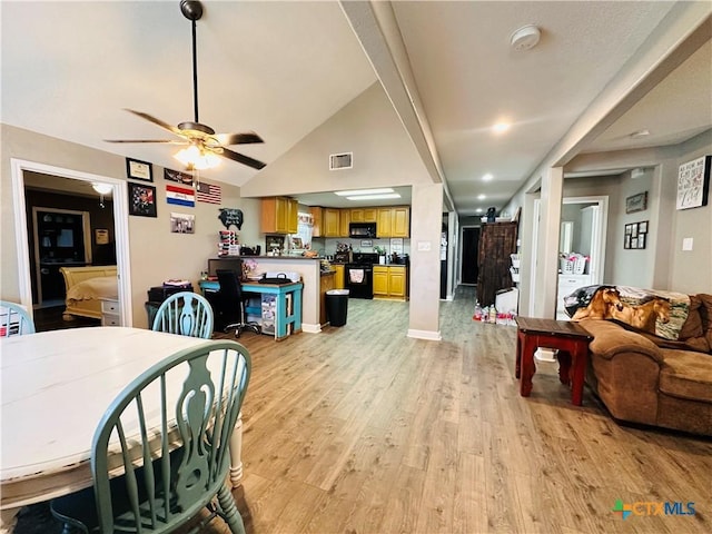 dining space featuring light wood-type flooring, vaulted ceiling, and ceiling fan