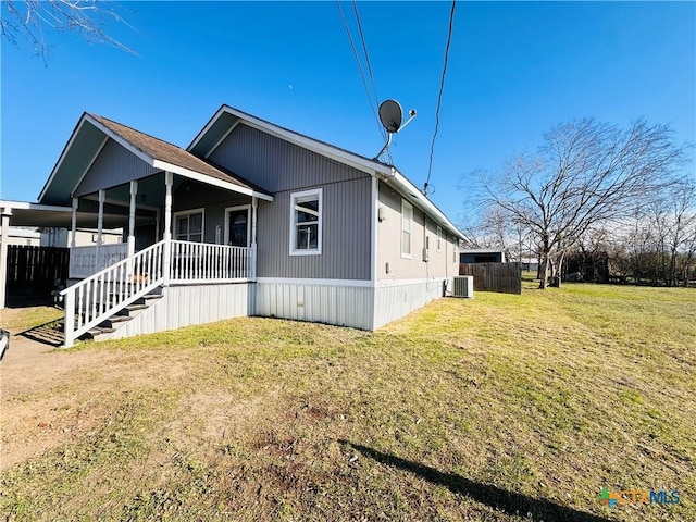 view of side of property with a lawn, cooling unit, and covered porch