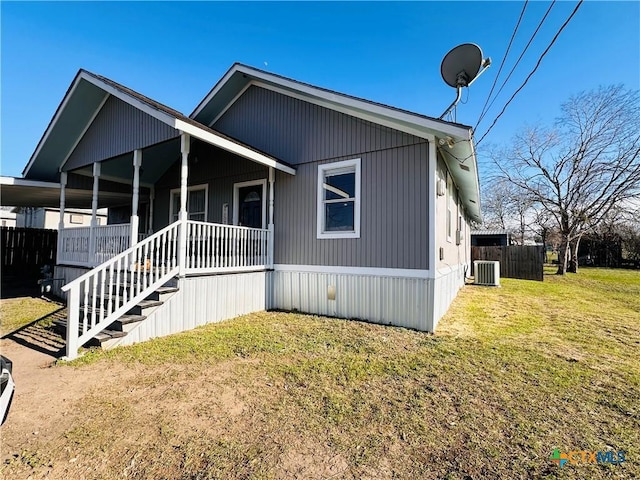 view of front of house with a front yard, a porch, and central AC