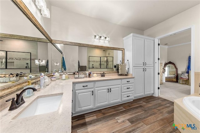 2755 Bowles Ranch Rd, Belton, TX 76513 - full bath featuring wood finished floors, double vanity, and a garden tub