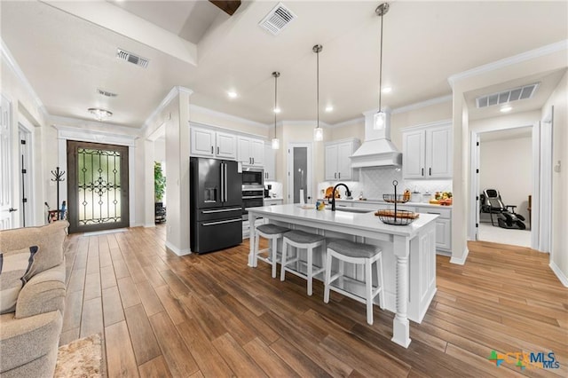 2755 Bowles Ranch Rd, Belton, TX 76513 - kitchen with stainless steel appliances, a kitchen bar, premium range hood, light countertops, and decorative backsplash