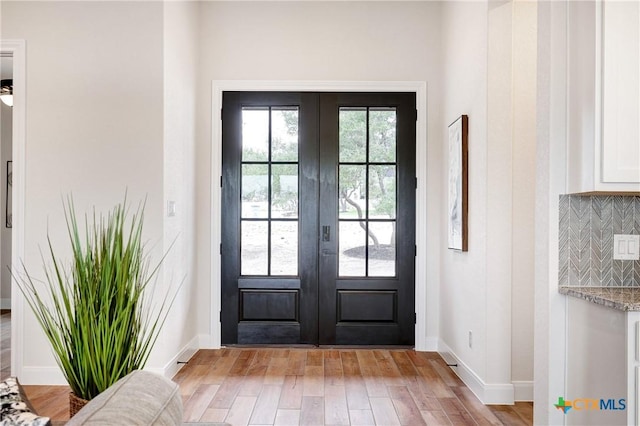 doorway with light hardwood / wood-style flooring and french doors