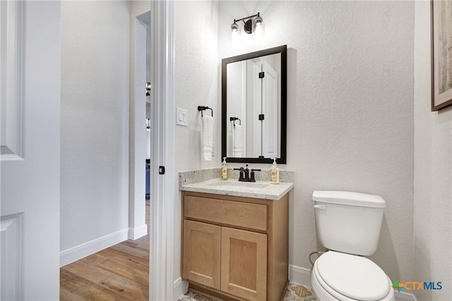 bathroom featuring vanity, hardwood / wood-style floors, and toilet