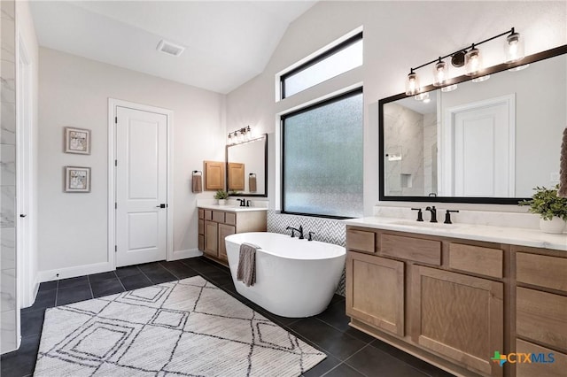 bathroom featuring tile patterned flooring, lofted ceiling, plenty of natural light, and a tub to relax in