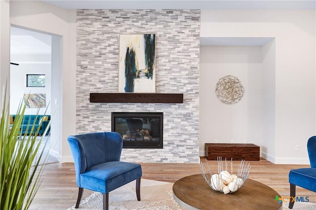 living area featuring a tile fireplace and wood-type flooring