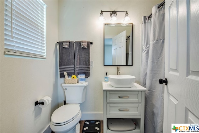 bathroom with vanity, toilet, plenty of natural light, and curtained shower