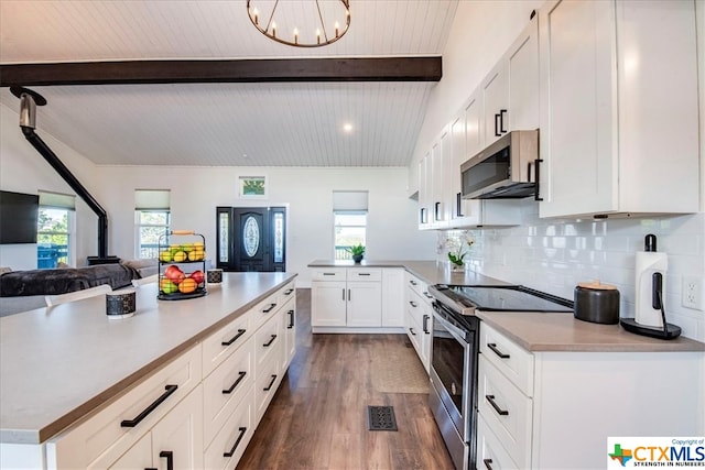 kitchen featuring white cabinetry, stainless steel appliances, beamed ceiling, a notable chandelier, and backsplash