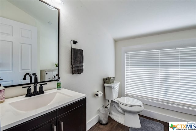 bathroom with vanity, toilet, wood-type flooring, and vaulted ceiling