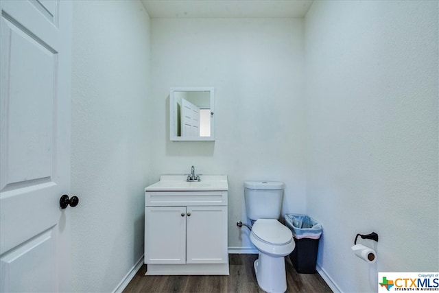 bathroom featuring vanity, hardwood / wood-style flooring, and toilet