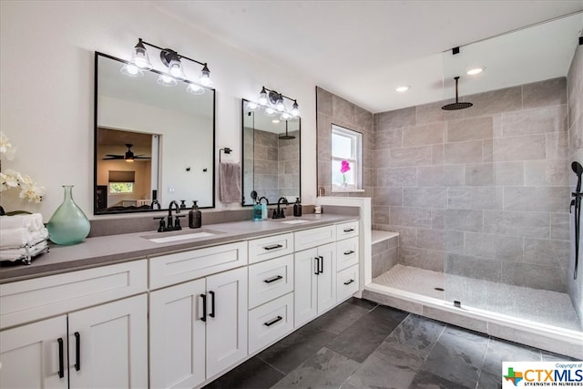 bathroom with vanity, ceiling fan, and tiled shower