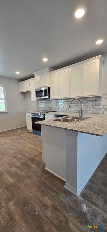 313 Monty Ave, Copperas Cove, TX 76522 - kitchen with a peninsula, stainless steel appliances, white cabinetry, backsplash, and recessed lighting
