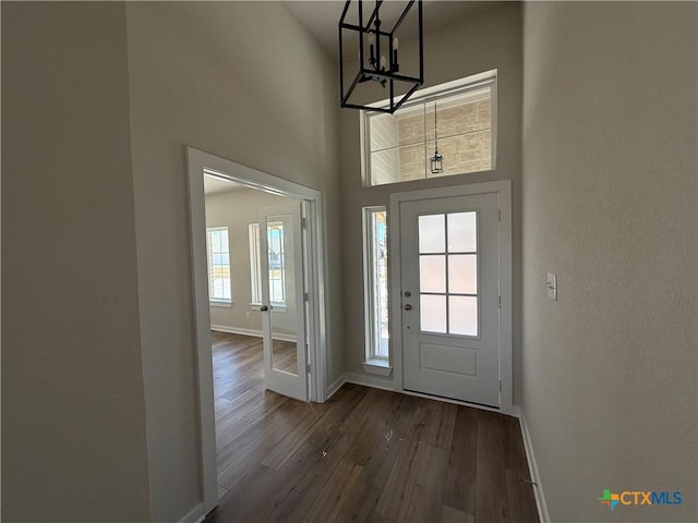 entryway featuring a towering ceiling and dark hardwood / wood-style floors