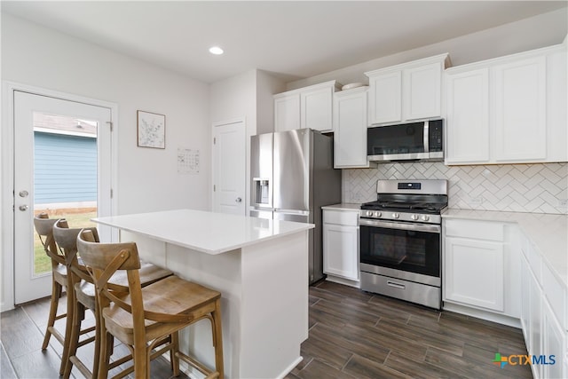 kitchen featuring stainless steel appliances, dark hardwood / wood-style floors, and white cabinets