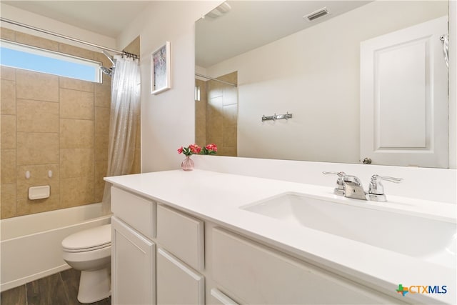 full bathroom featuring hardwood / wood-style floors, vanity, toilet, and shower / bath combination with curtain